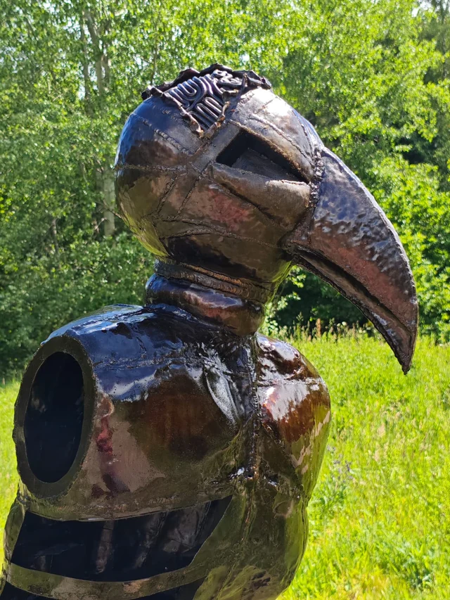 Vogelkopf und Rumpf der geschmiedeten Stahlfigur Hugo aus seitlicher Perspektive.