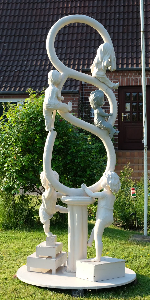 Weiße Kinderfigurengruppe an Ringen aus einer anderen Blickrichtung mit vollständiger Grundplatte